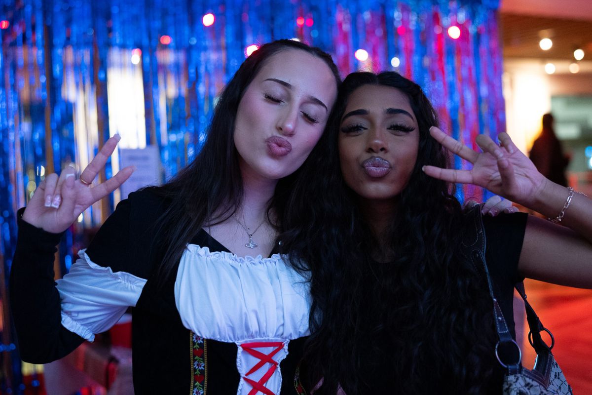 Two friends pout and show peace signs