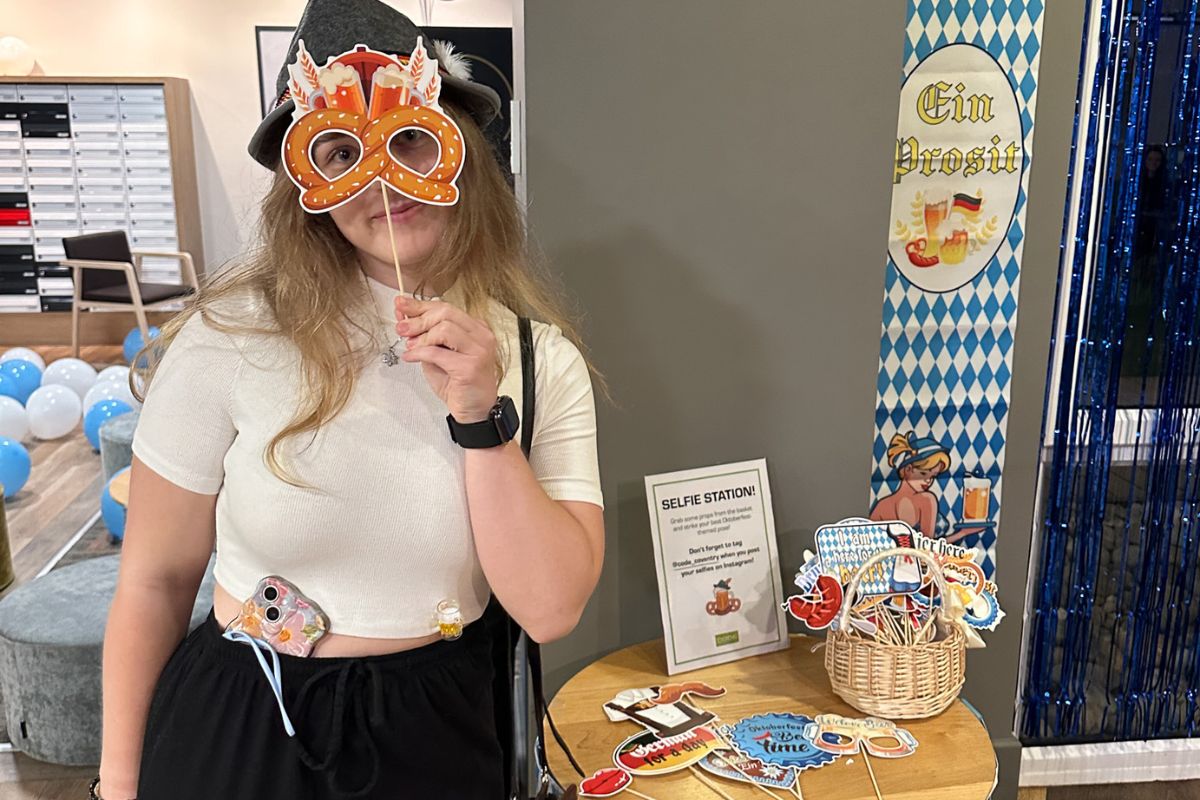 Student at the selfie station holds a pretzel-shaped mask