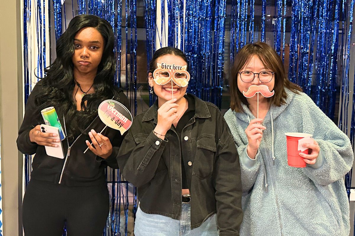 Three friends pose at the selfie station