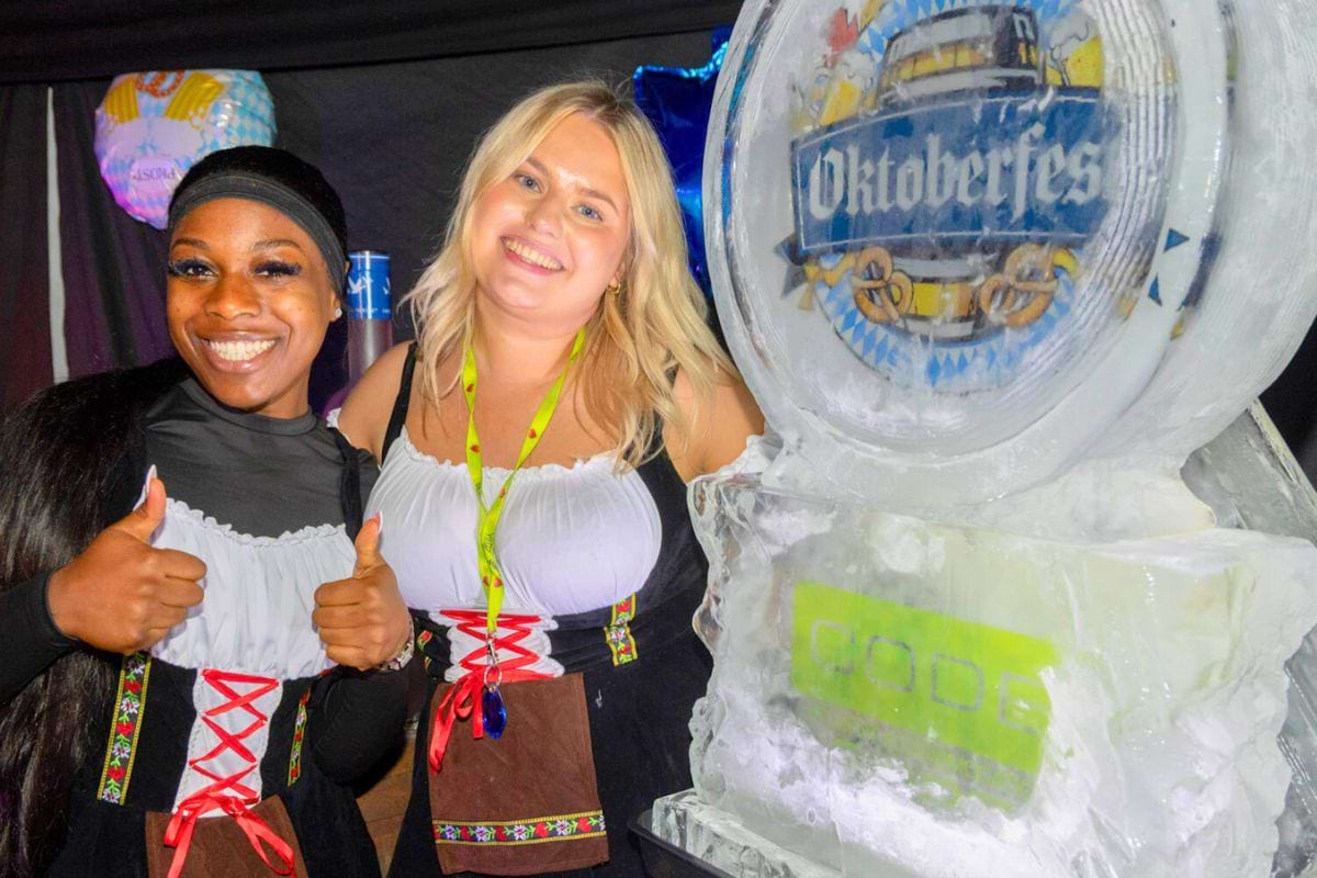 CODE staff stand next to the Oktoberfest vodka luge