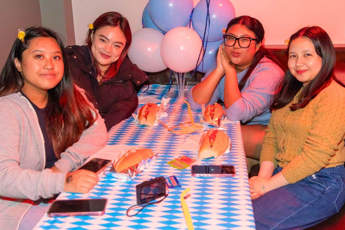 CODE student tenants eating hotdogs at the table