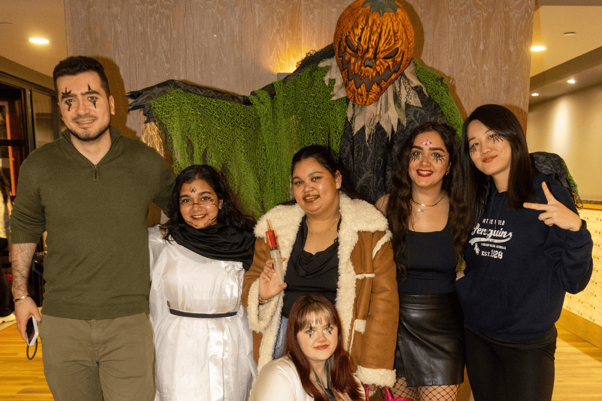 CODE Halloween Bingo a friend group posing with the decorations