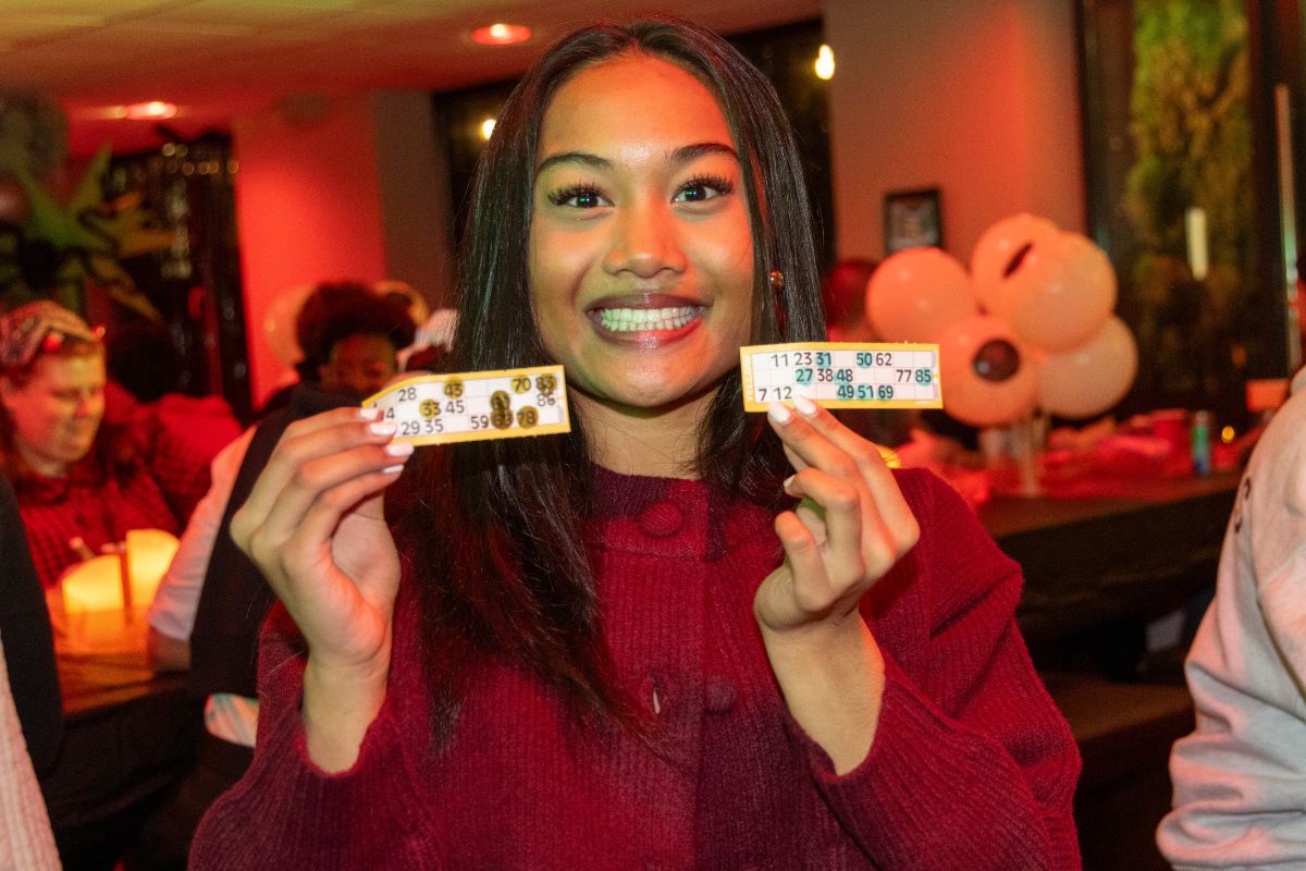 A CODE student holding up their bingo cards