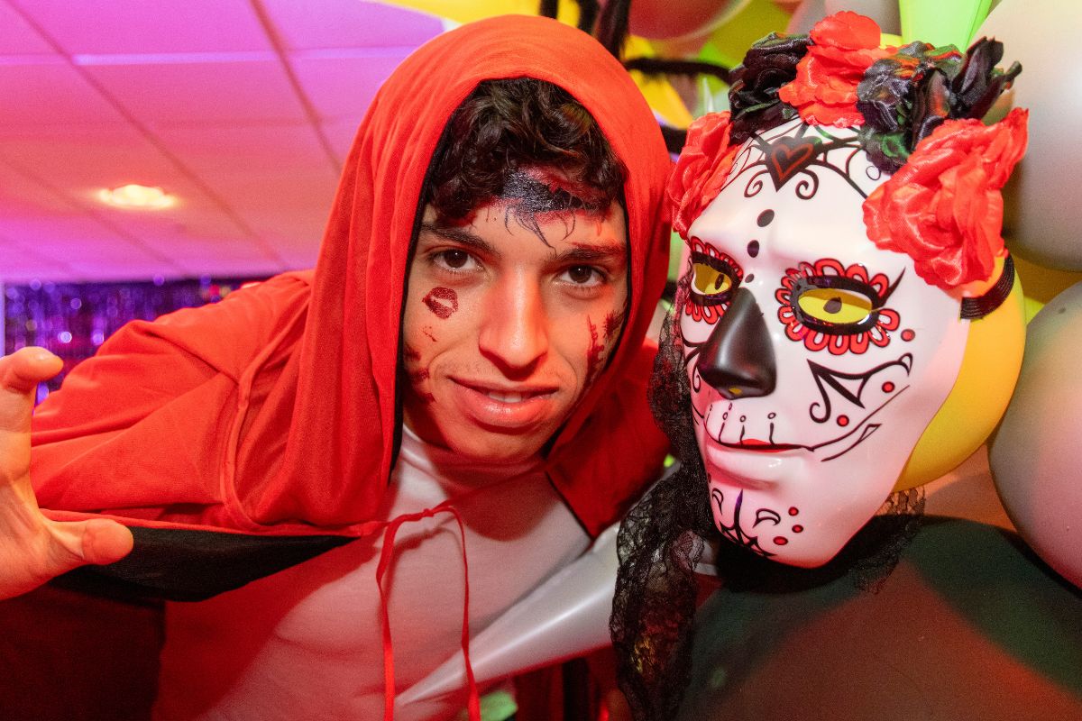 A CODE tenant dressed in fancy dress posing with a scary mask