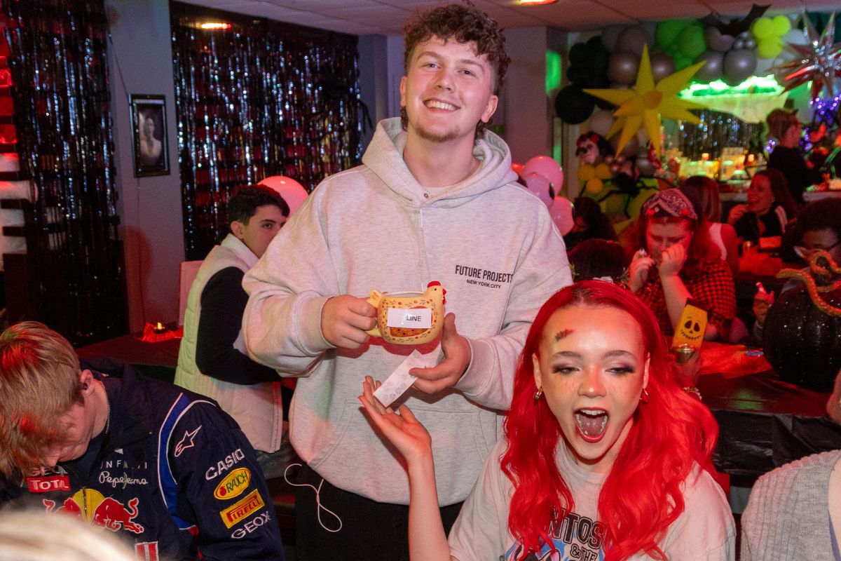 A bingo winner holding their prize - a mug shaped like a chicken