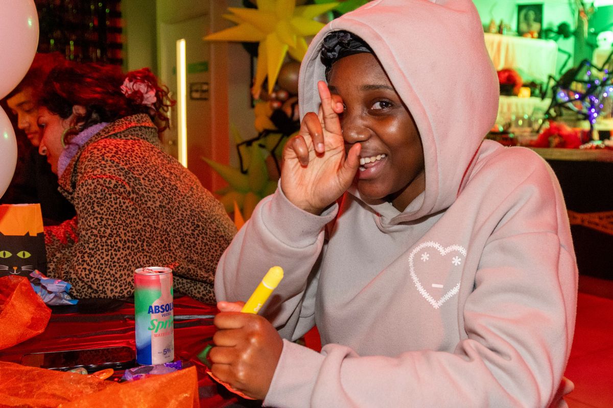 A cODE student crossing their fingers, hopping to win at the halloween bingo