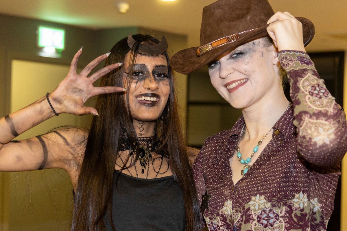 Two CODE tenants in fancy dress posing in front of the camera
