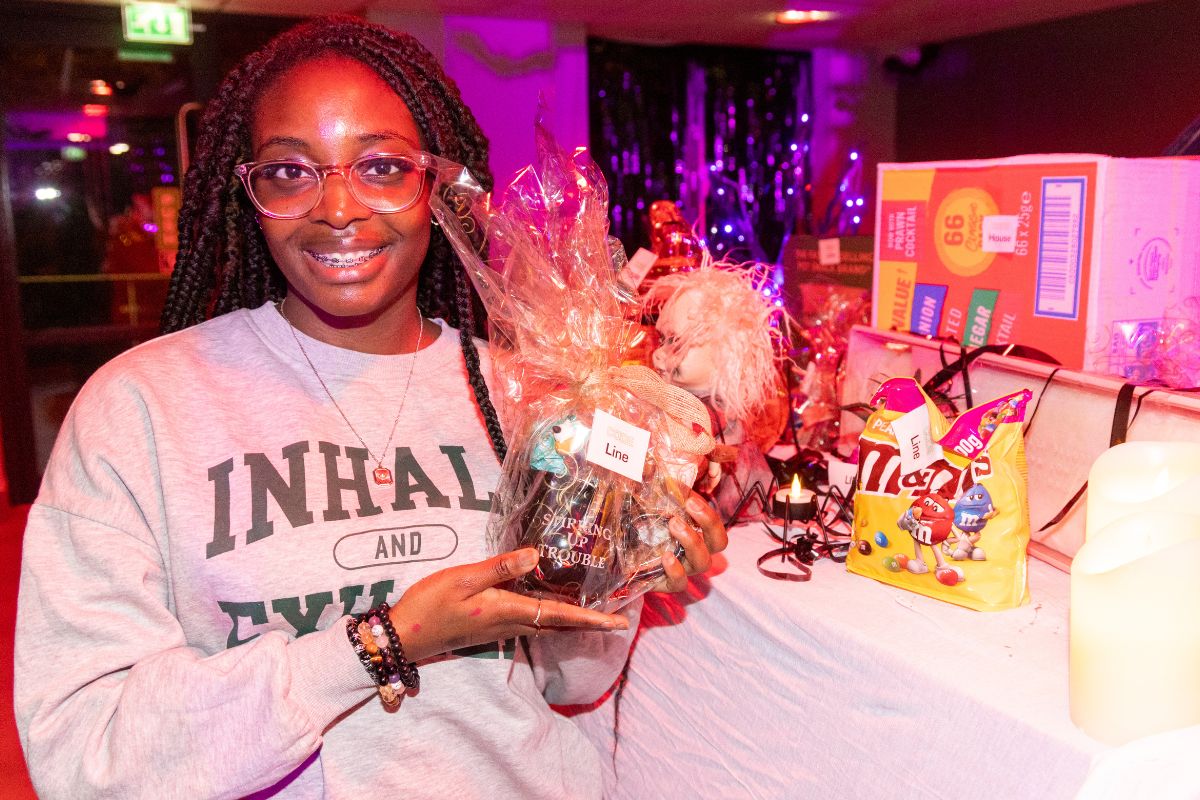 A winner at the CODE halloween bingo holding their prize