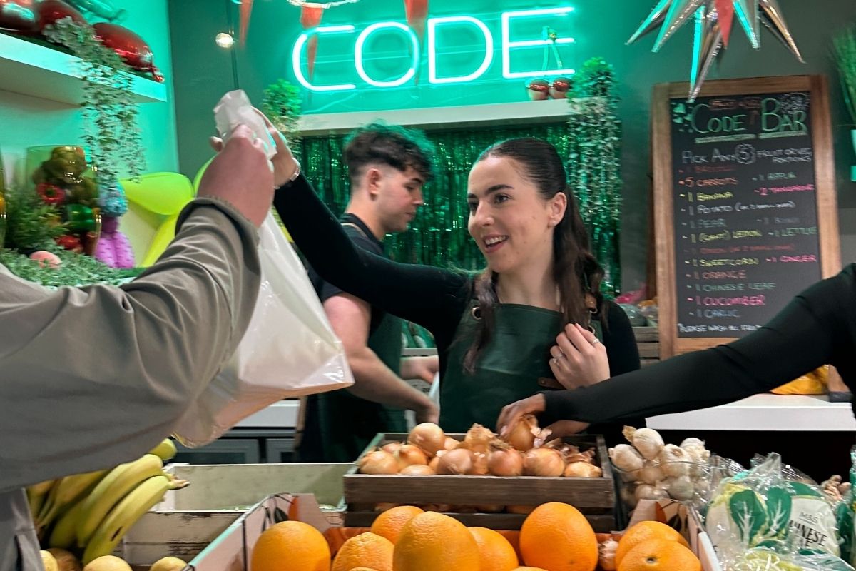 A CODE student ambassador tending the cafee to give out fruit ad veg