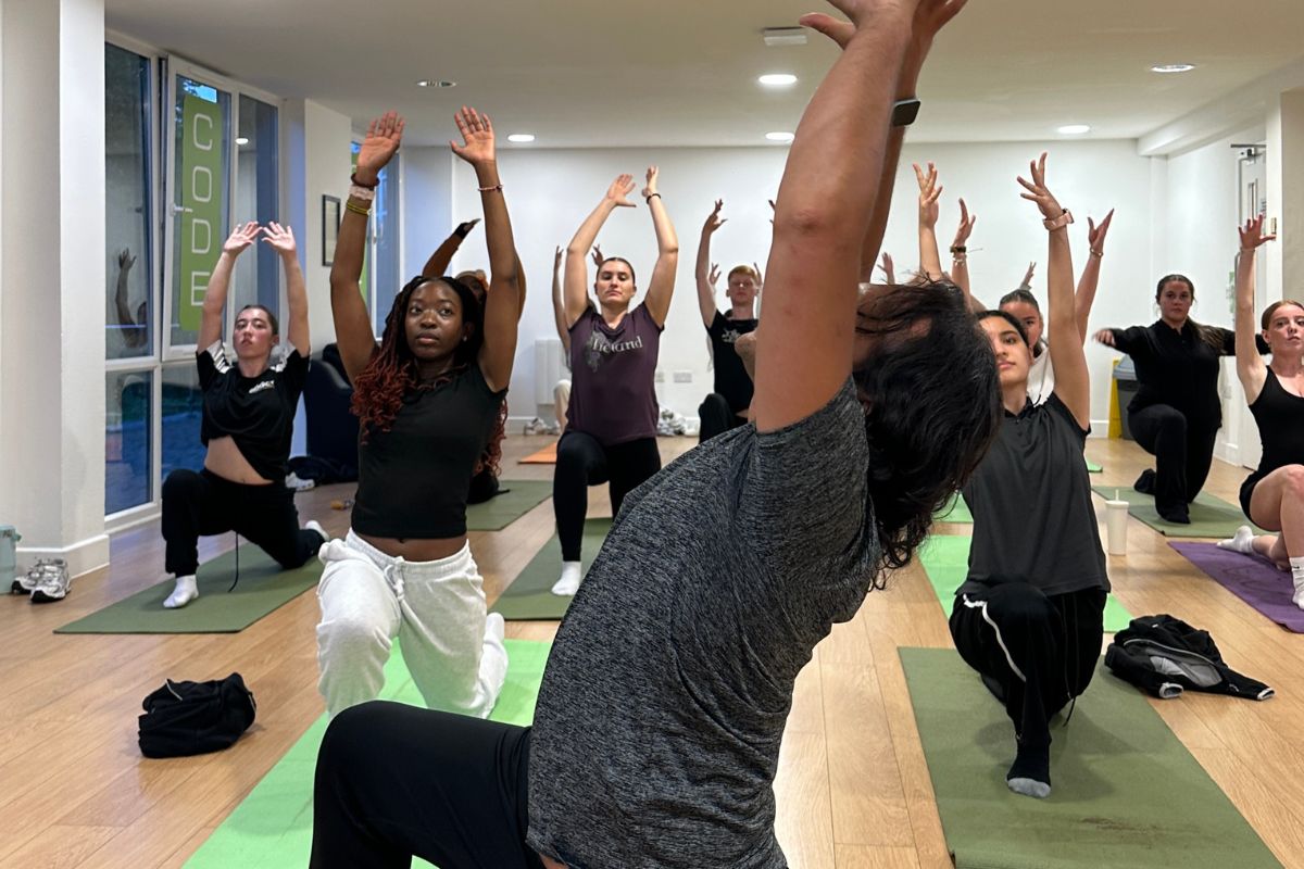Yoga teacher instructing the CODE students at the yoga event
