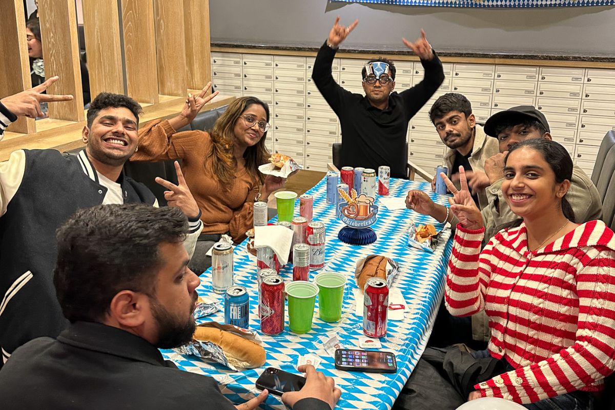 Seven friends pose around the table with big smiles