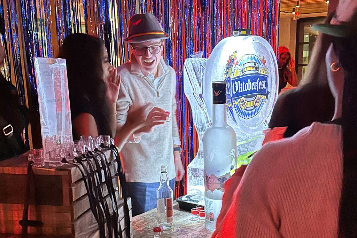 A student smiles at the vodka luge table