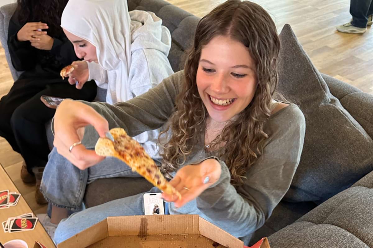 girl holding up a pizza slice
