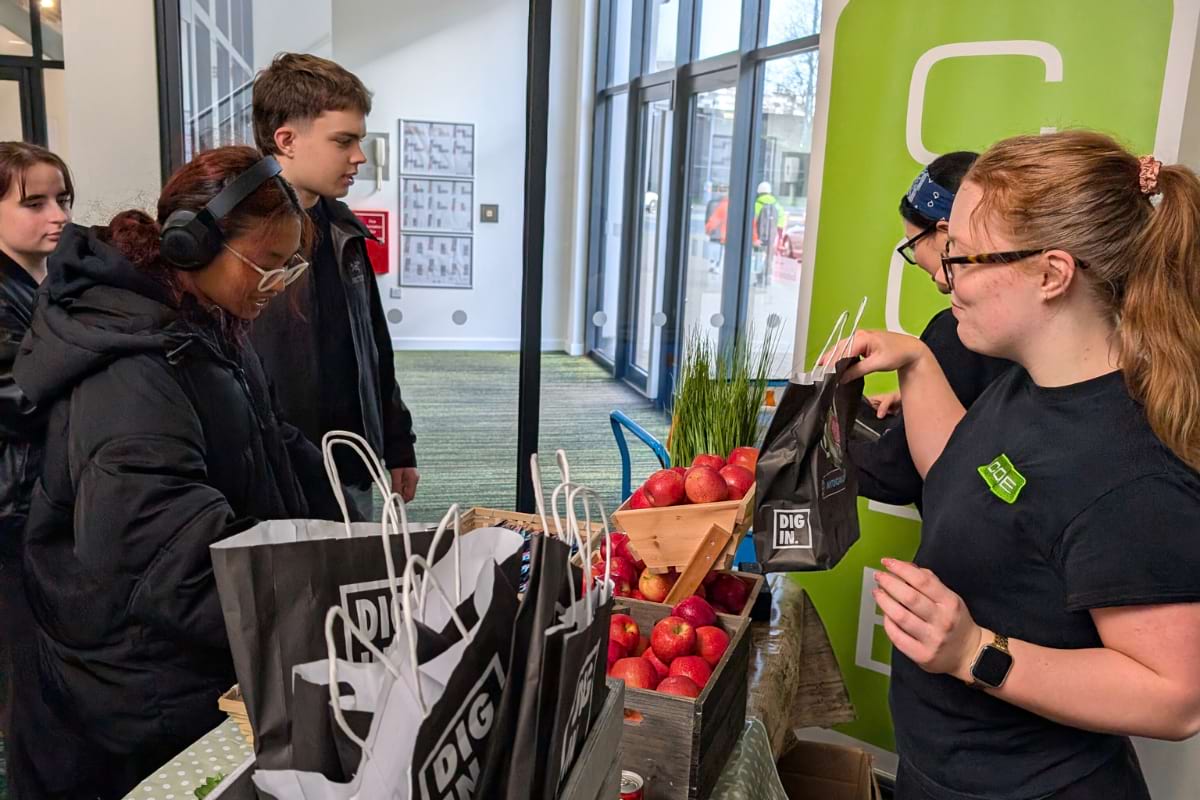 2 girl staff handing bags to students