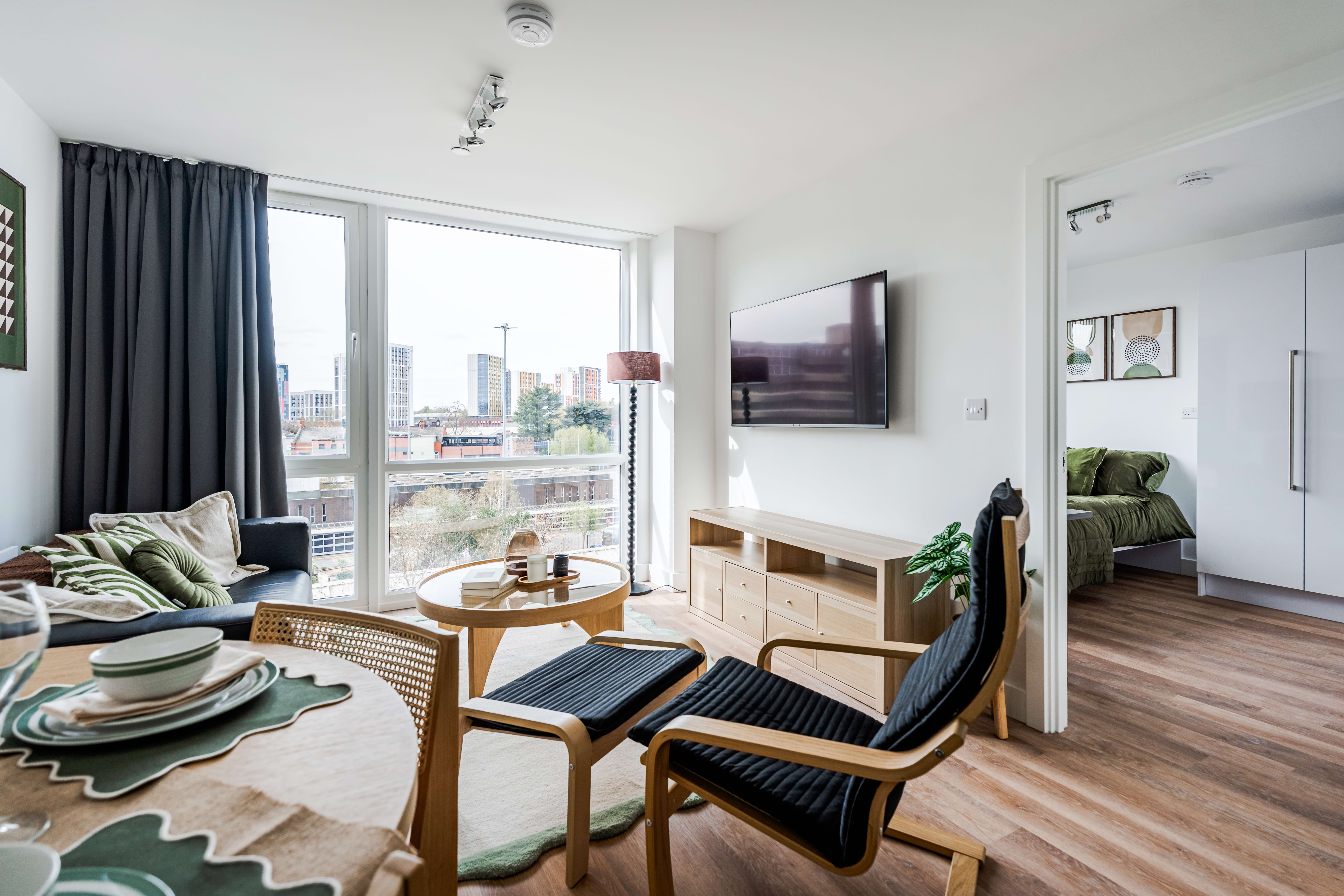 Living area with large windows, a 55'' TV, and sofa.