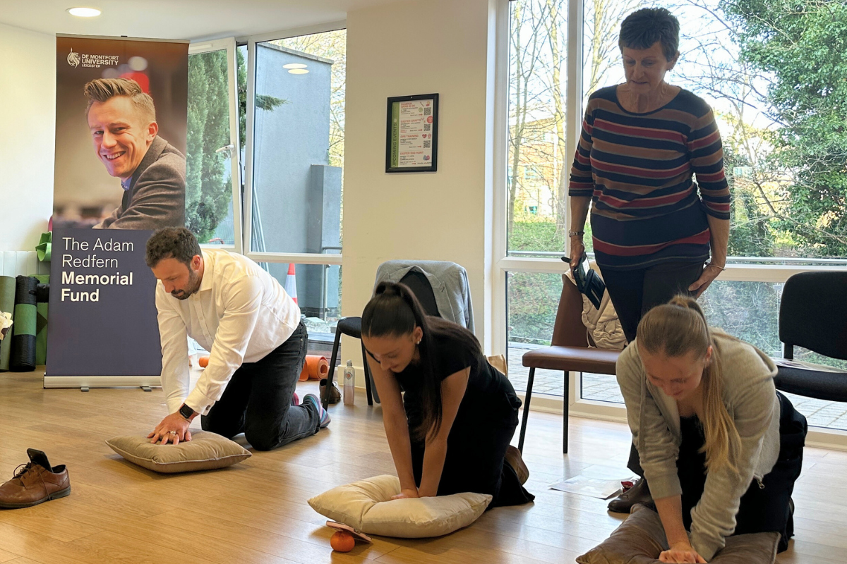 Students practicing CPR on their pillows at the CODE CPR training event together with the Adam Redfern Memorial