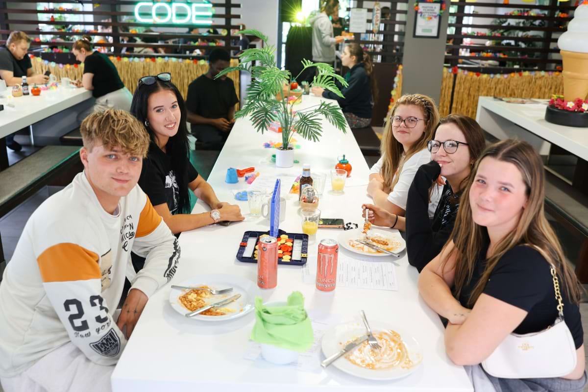 5 students sat down smiling for photo