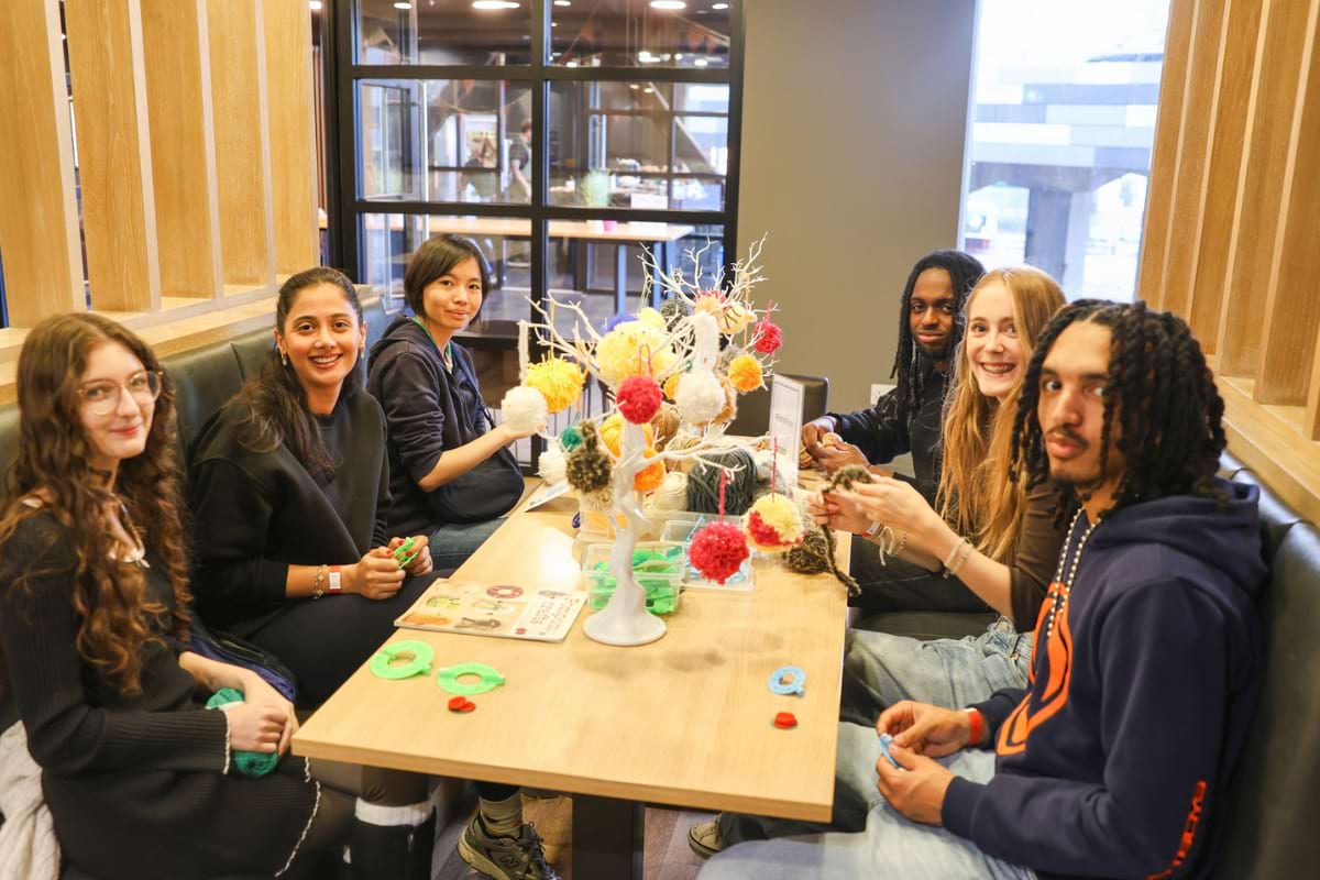 tenants making pom poms - posing for photo
