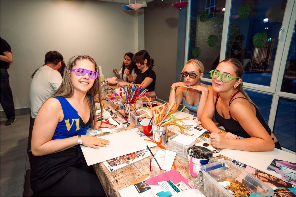 3 girls posing for photo sitting at crafting table