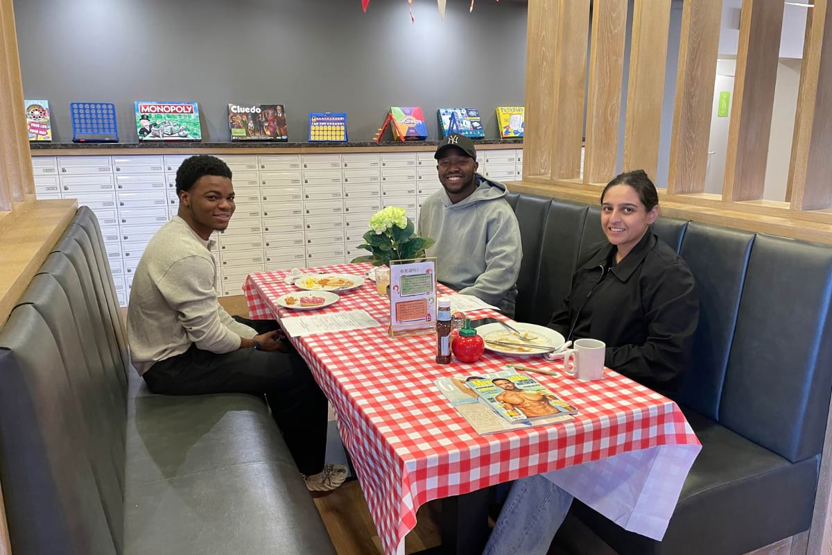 3 students posing for photo - eating breakfast at event