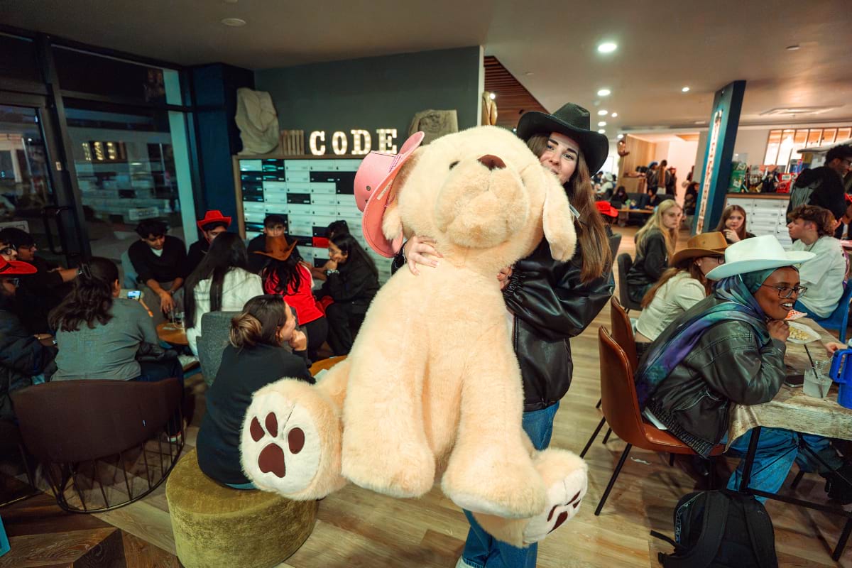 student posing with large dog toy