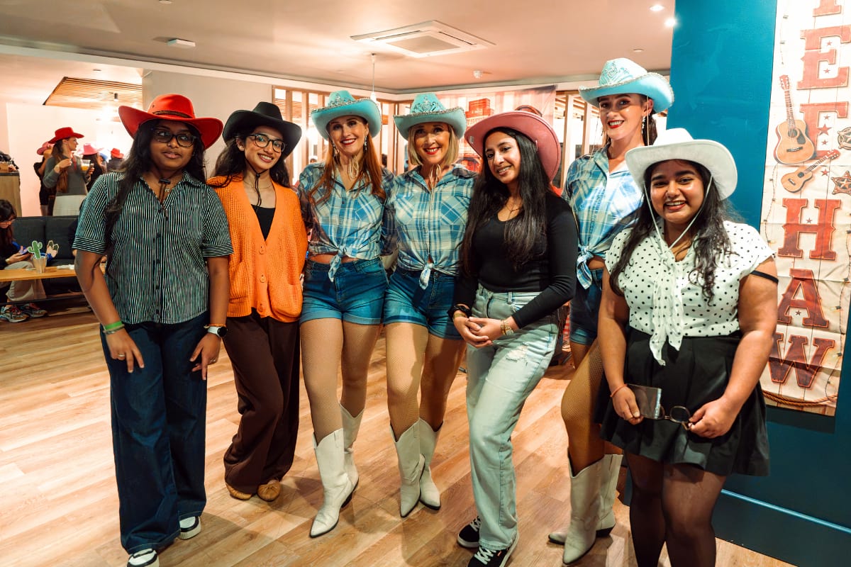 students smiling for photo wearing cowboy hats