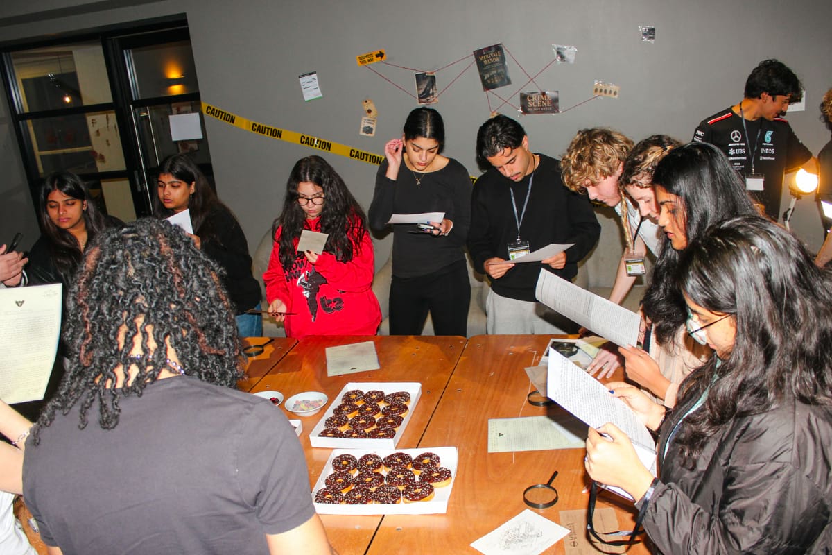 tenants standing a table during a murder mystery event, with an FBI-dressed host.