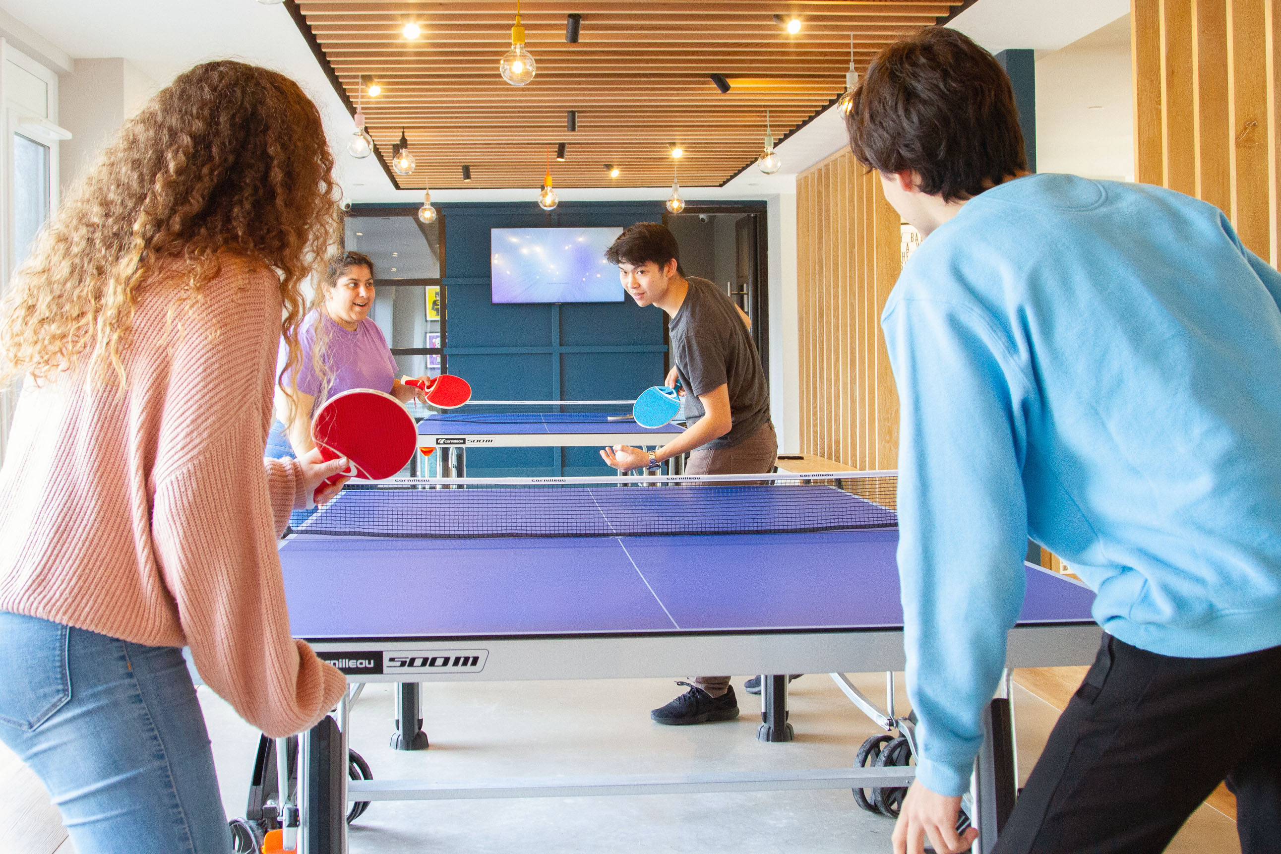 Students playing table tennis in the communal room at CODE Student Accommodation Coventry
